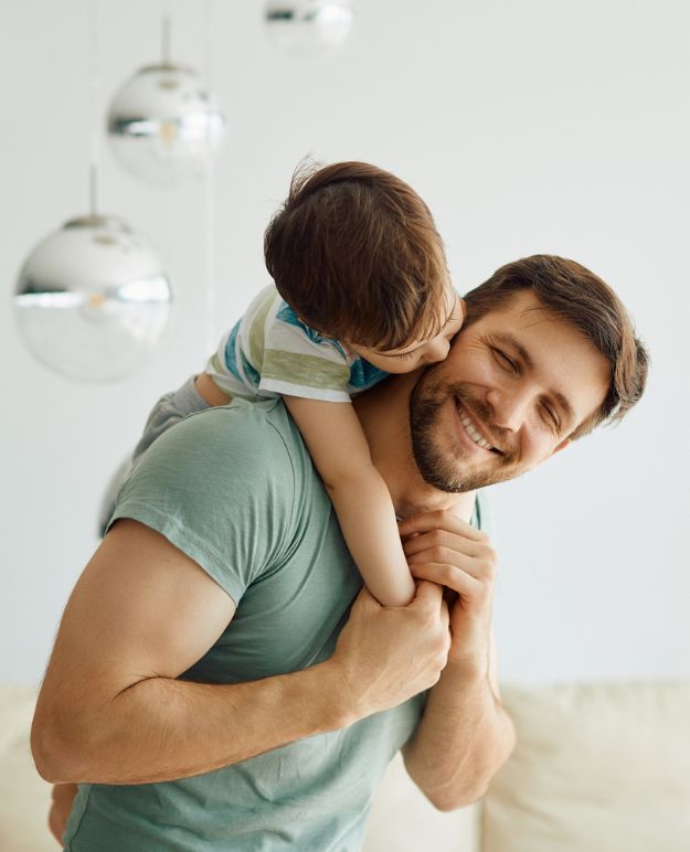 A father playing with is son in the living room of their home.