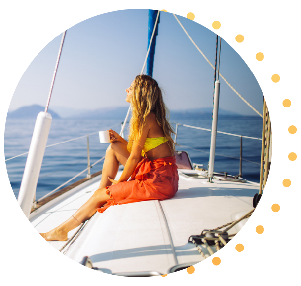 A woman relaxed with a coffee on the deck of her sailboat.