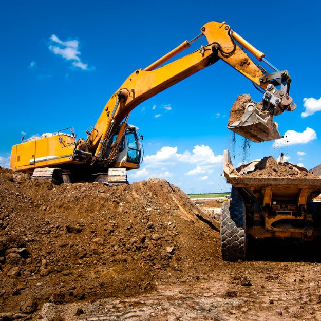 Heavy construction equipment excavating a construction site.