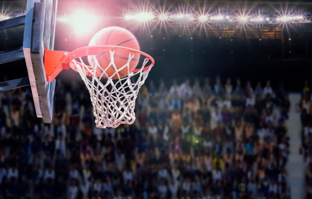 A close-up of a basketball going in the basket.