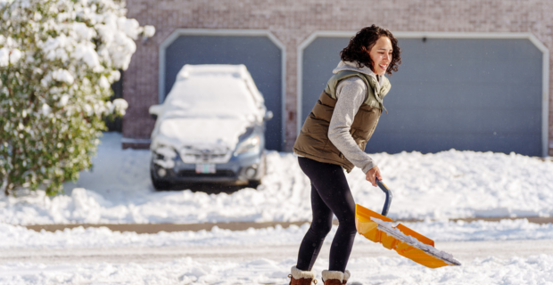 A woman shoveling snow during the winter.